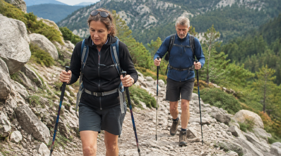 Pelerins marchant sur sentier rocailleux avec batons
