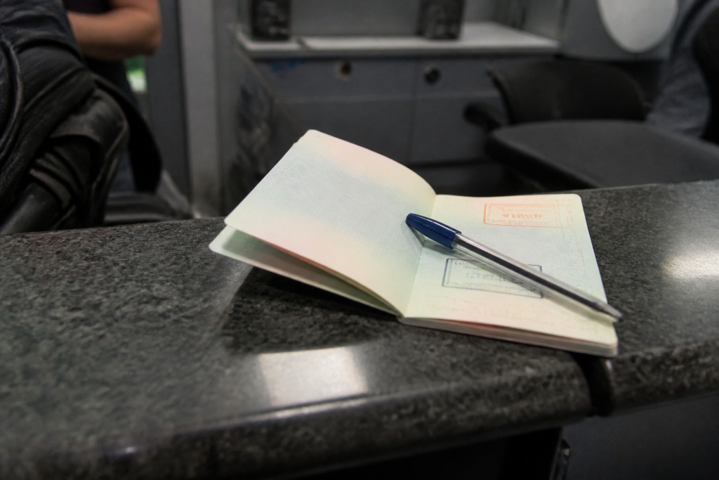 Passeport etranger ouvert avec stylo bleu sur comptoir aeroport