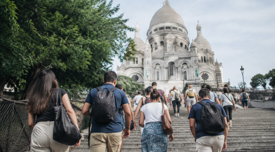 Touristes montent escaliers direction basilique blanche surplomb
